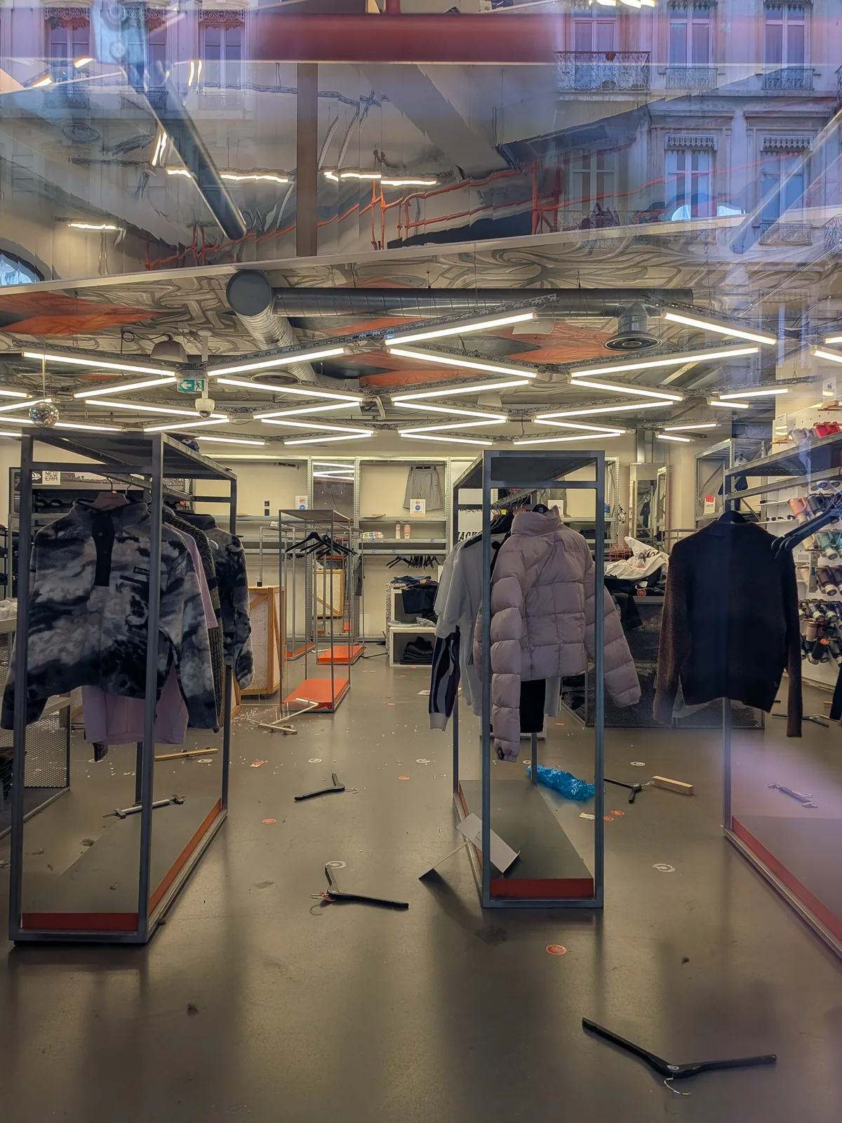 Intérieur du magasin Citadium à Lyon avec des débris et des portants après les manifestations