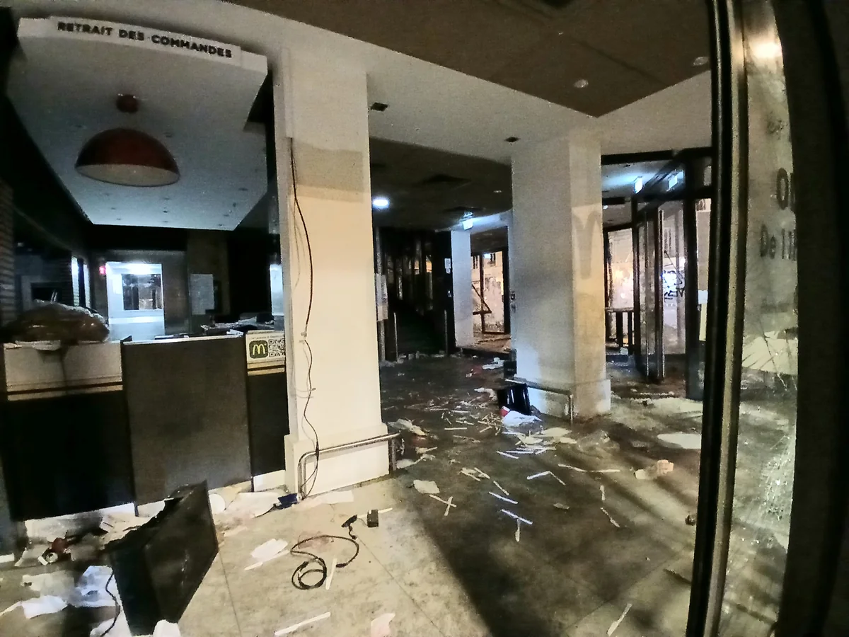 Entrée vitrée et intérieur d’un commerce endommagés avec des débris au sol, faubourg Saint-Denis à Paris le 18 octobre 2026.